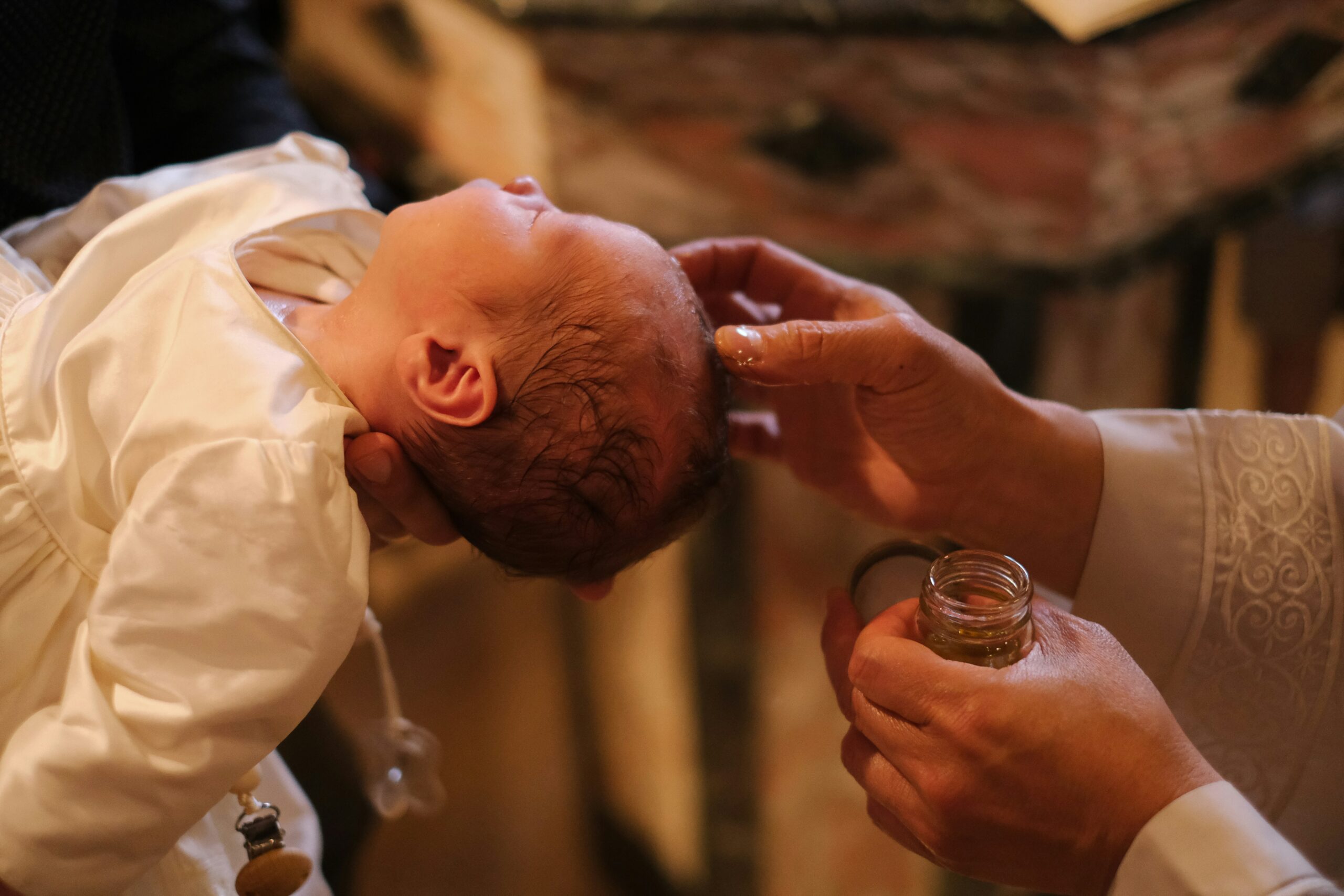 Baby being anointed with oil during Baptism