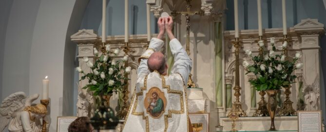 Priest holding up the Holy Eucharist